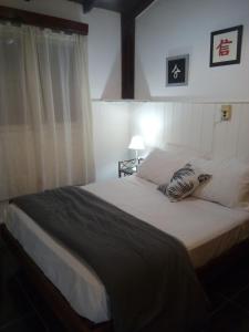 a bedroom with a large bed with white sheets at Casa Mar de Cobo in Mar de Cobo