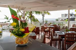 un jarrón de flores sobre una mesa en un restaurante en Sint Maarten Blue Dream 1BR (C), en Cupecoy