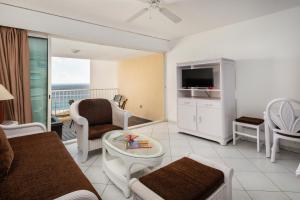 a living room with a couch and a tv at Sint Maarten Blue Dream 1BR (C) in Cupecoy