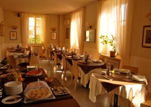 a dining room with tables and chairs with food at Hotel Giglio in Salsomaggiore Terme