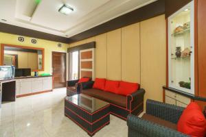 - un salon avec un canapé et des oreillers rouges dans l'établissement RedDoorz Syariah @ Mora Garden Bungo, à Bebeko