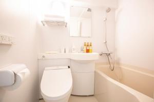a white bathroom with a toilet and a sink at HOTEL MYSTAYS Higashi Ikebukuro in Tokyo +16 photos