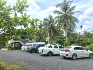 eine Reihe von Autos auf einem Parkplatz in der Unterkunft Baan Bang Kluai Resort บ้านบางกล้วย รีสอร์ท in Surat Thani + 19 Fotos