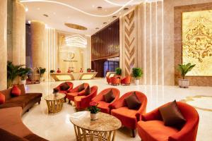 a lobby with orange chairs and tables in a building at Regalia Gold Hotel in Nha Trang