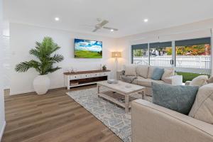 a living room with a couch and a table at Walk to Hastings Street, Noosa Sound in Noosa Heads