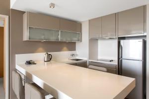 a kitchen with a white counter and a refrigerator at Chateau Royal Beach Resort & Spa, Noumea in Noumea