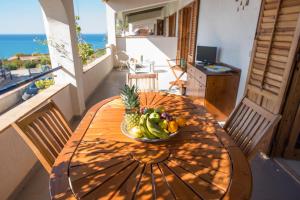 un tavolo in legno con un cesto di frutta sopra di Sea Front Apartment 5 beds with balcony 250 meters from the beach a Case San Marco