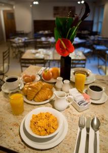 a table with plates of breakfast food and orange juice at New Linden Hotel in London