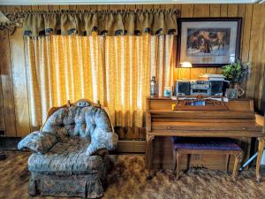 a living room with a chair and a piano at Three Bears Inn in Saint Anthony