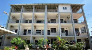 a large white building with balconies on it at Sevenstars Hostel in Sihanoukville