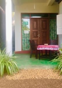a dining room with a table and a door at Vivid Lanka in Bentota