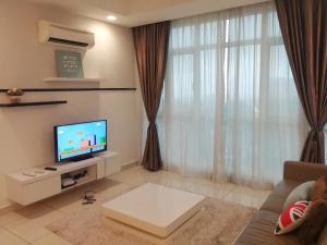 a living room with a couch and a television at Homestay Kuala Lumpur ; Terminal TBS ; Bukit Jalil in Kuala Lumpur