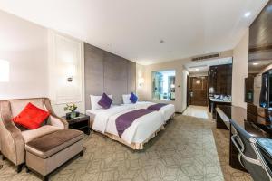 a bedroom with a large bed and a chair at Dorsett Wuhan in Wuhan