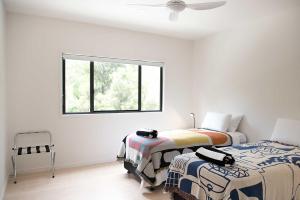 Acacia Villa في نوسا هيدز: غرفة نوم بها سريرين ونافذة