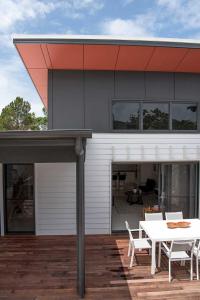 Acacia Villa في نوسا هيدز: منزل بسقف أحمر وطاولة على السطح