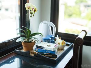 ein Tablett mit Büchern und einer Pflanze auf einem Fensterbrett in der Unterkunft La Pillow 8 in Chiang Mai