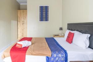 ein Schlafzimmer mit einem Bett mit bunten Decken und Kissen in der Unterkunft RedDoorz Plus near Tambun Station in Bekasi