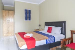 a bedroom with a bed with a box on it at RedDoorz Plus near Tambun Station in Bekasi