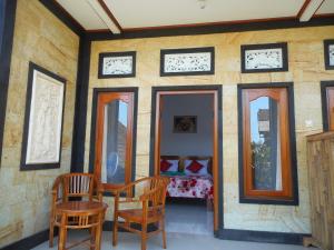 a room with a table and chairs and mirrors at Ming Homestay in Sidemen