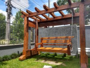 a wooden bench sitting in a swing at Casa Joaninha centro in Canela