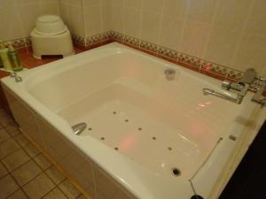 y baño con bañera blanca grande. en HOTEL Rplus Higashimatsuyama en Namegawa