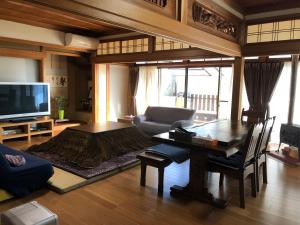 a living room with a table and a television at familie in Otsu