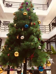 a green christmas tree with ornaments on it at Sarvodaya Samma Vaasa Residence in Kandy