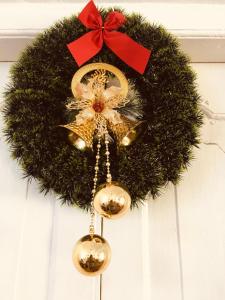 a christmas wreath with gold bells and a red bow at Sarvodaya Samma Vaasa Residence in Kandy