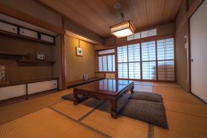 a living room with a table in the middle of a room at K's House Kanazawa - Travelers Hostel in Kanazawa