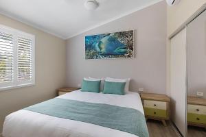 a bedroom with a bed and a painting on the wall at BIG4 Adventure Whitsunday Resort in Airlie Beach