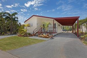 a house with a red roof on a street at BIG4 Adventure Whitsunday Resort in Airlie Beach
