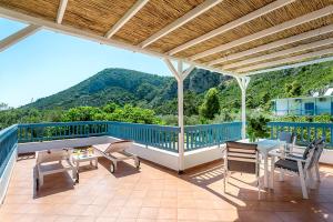 a patio with a table and chairs on a roof at Limnonari Split Level Studio in Skopelos Town
