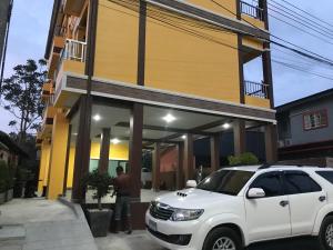 a white suv parked in front of a building at G-HAN Residence in Nai Yang Beach