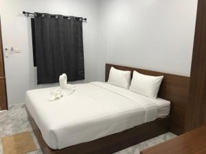 a bedroom with a white bed with a black curtain at G-HAN Residence in Nai Yang Beach
