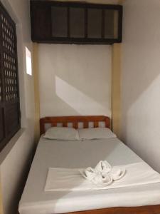 a bed with two white towels on top of it at COFFEESWINGS LODGING HOUSE in Vigan