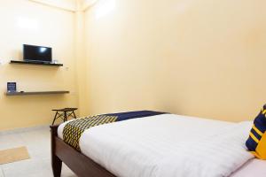 um quarto com uma cama e uma televisão na parede em SPOT ON 2063 Bethania Residence em Kupang