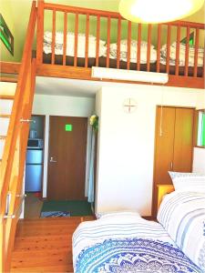 a bedroom with two bunk beds and a staircase at ALOALO BEACH 川平 in Fukai