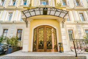- un bâtiment avec une grande porte en bois et un balcon dans l'établissement Sadovnicheskaya Suites, à Moscou