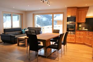 a kitchen and dining room with a wooden table and chairs at Chalet Mila in Grindelwald