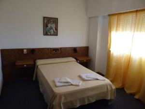 Una cama o camas en una habitación de Hotel La Argentina