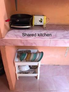 una pequeña cocina con una cocina a la sombra con un estante en Rimsuan House, en Ko Lanta