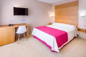 Schlafzimmer mit einem Bett, einem Schreibtisch und einem TV in der Unterkunft Mediterraneo Bay Hotel & Resort in Roquetas de Mar