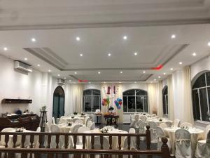 Hotel Vietri Coast في فيتري: قاعة احتفالات بطاولات بيضاء وكراسي بيضاء