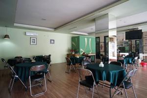 a room with tables and chairs with green table cloth at OYO 2015 Bandara Hotel Balikpapan in Balikpapan