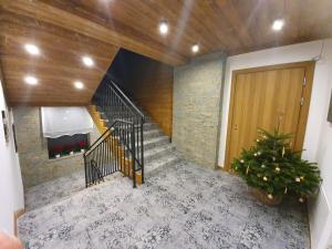 Una escalera en una casa con una planta y una puerta en Apartamenty Pod Tatrzańskim Niebem en Zakopane