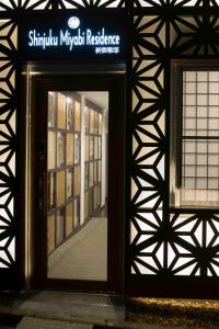 an open door to a building with a sign on it at Shinjuku Miyabi Residence in Tokyo