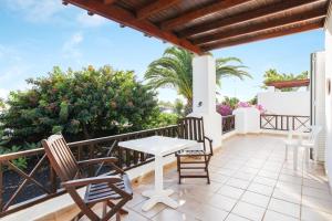 Un patio con sillas y una mesa en un balcón. en Villa Isa, en Playa Blanca