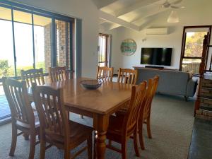 a dining room with a wooden table and chairs at Beachside House in Kingscote