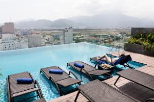 a woman laying on the edge of a swimming pool on a building at VENTANA NHA TRANG HOTEL in Nha Trang