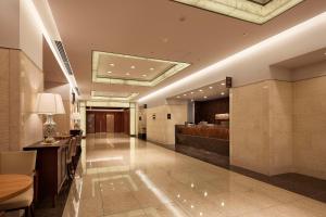 a lobby of a hotel with a bar in the middle at Hearton Hotel Kita Umeda in Osaka